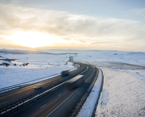 Highway road over the mountains with speeding cars and trucks